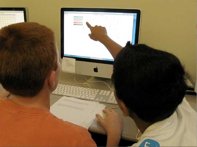 Boys pointing at computer screen with EcoMUVE